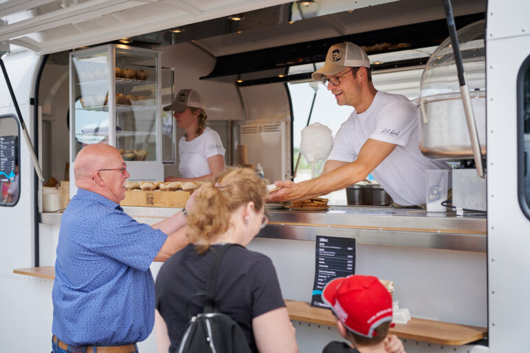 Begeisterte Gäste bei der Annahme von frisch zubereiteten Burgern aus dem Foodtruck des Caterer Caab aus Mönchengladbach.